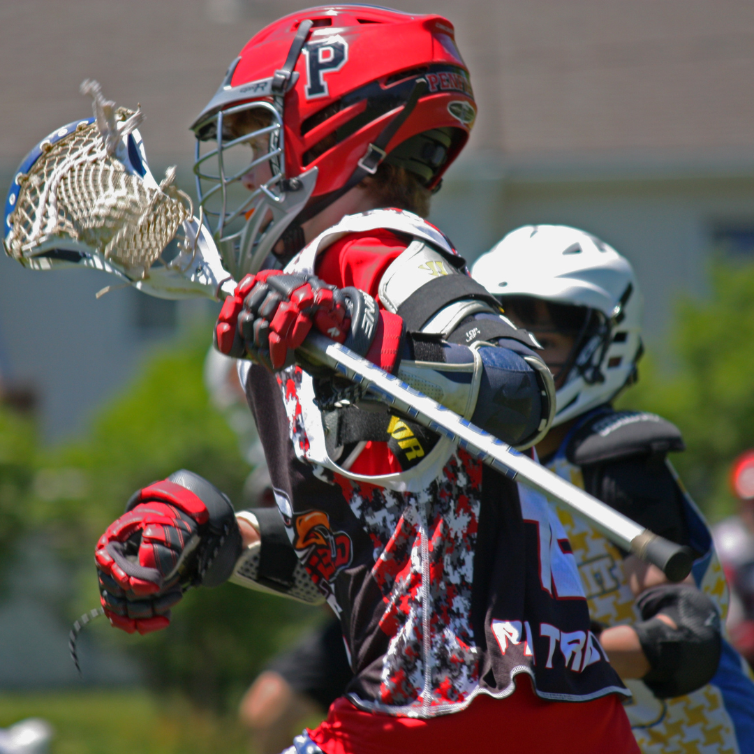 A lacrosse player using a wooden lacrosse shaft.